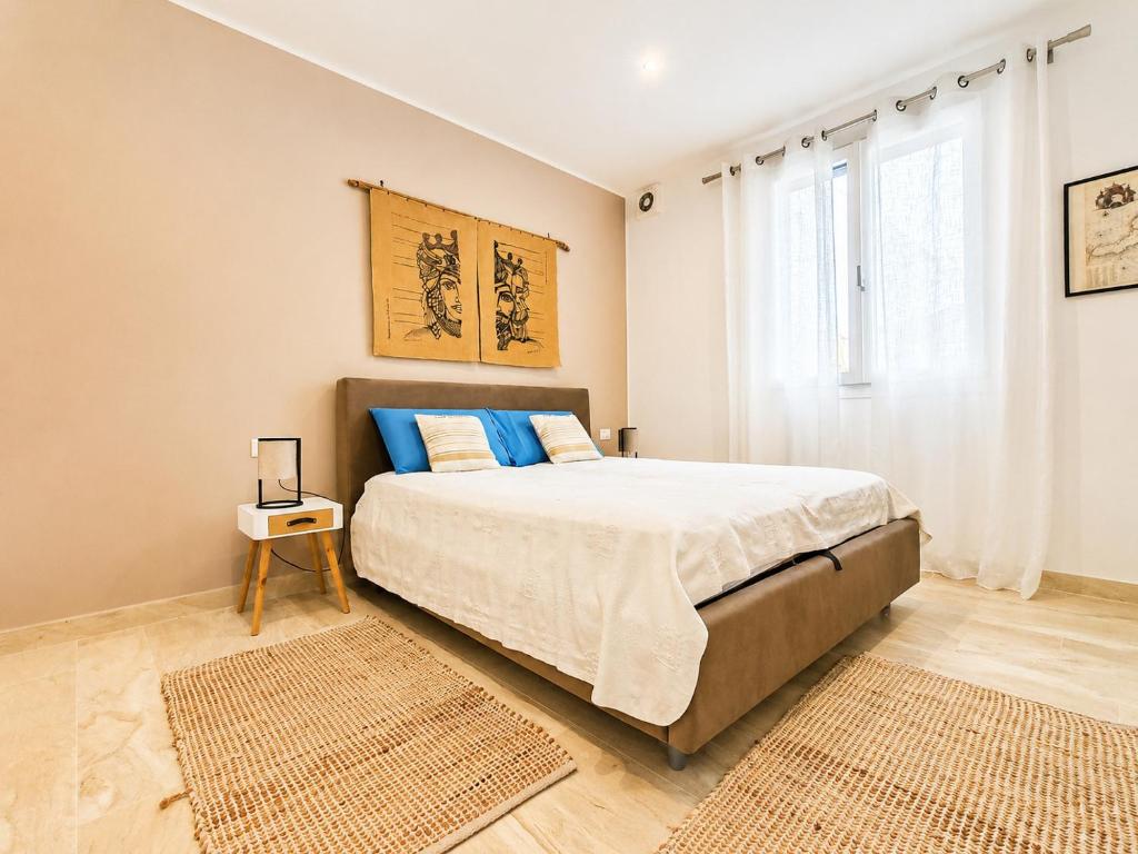 a bedroom with a large bed with blue pillows at Villa Dolce Vita in Triscina