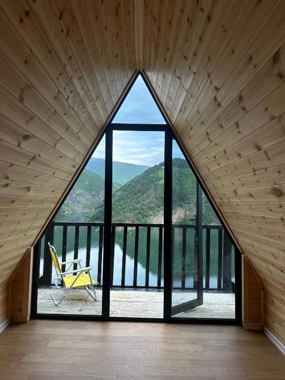 a room with a large window with a chair on a balcony at Camping Temali T&M in Arrëz
