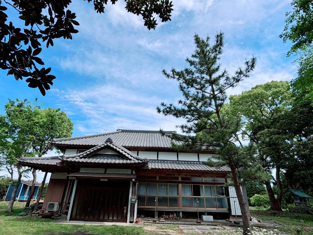 a house with a tree in front of it at Edo house in Shiigi