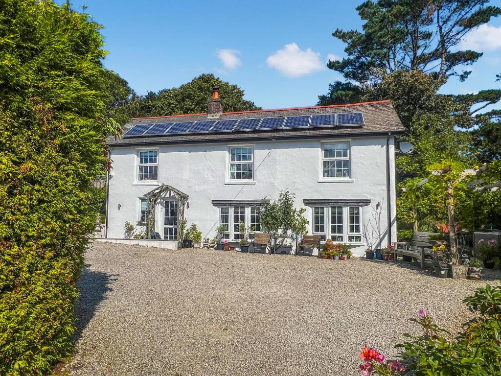 a white house with solar panels on the roof at Rosehill in Truro