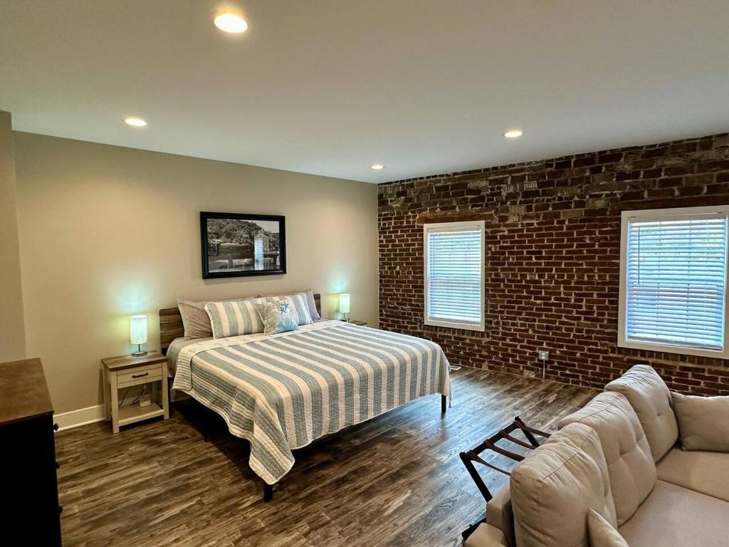 a bedroom with a bed and a brick wall at Mill View Suite - River Rock Inn in Bellevue