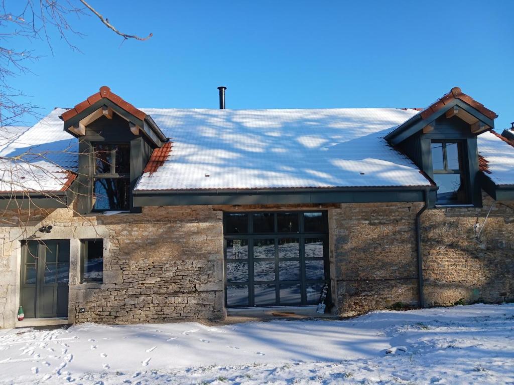 a house with a snow covered roof on top of it at La R'mise de Surcey in Alaise