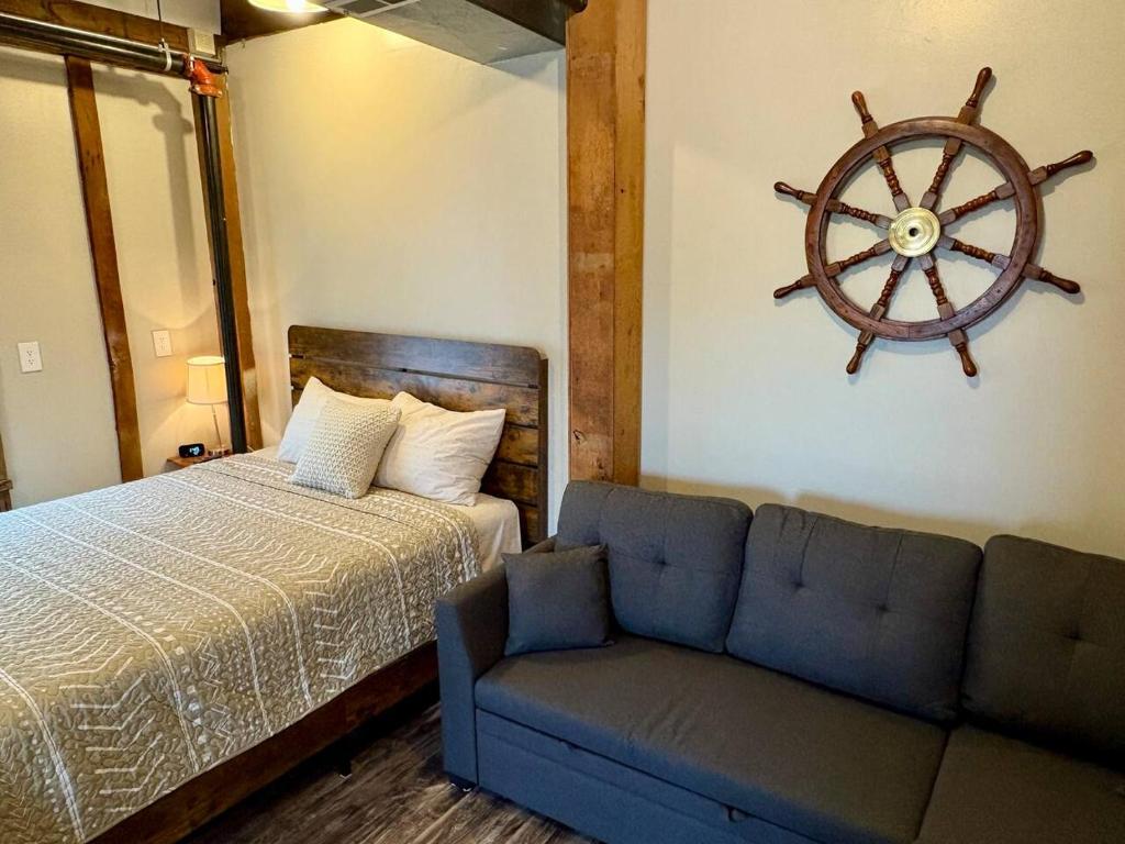 a bedroom with a bed and a couch and a wheel on the wall at Paddle Wheel Suite-Potter’s Mill in Bellevue