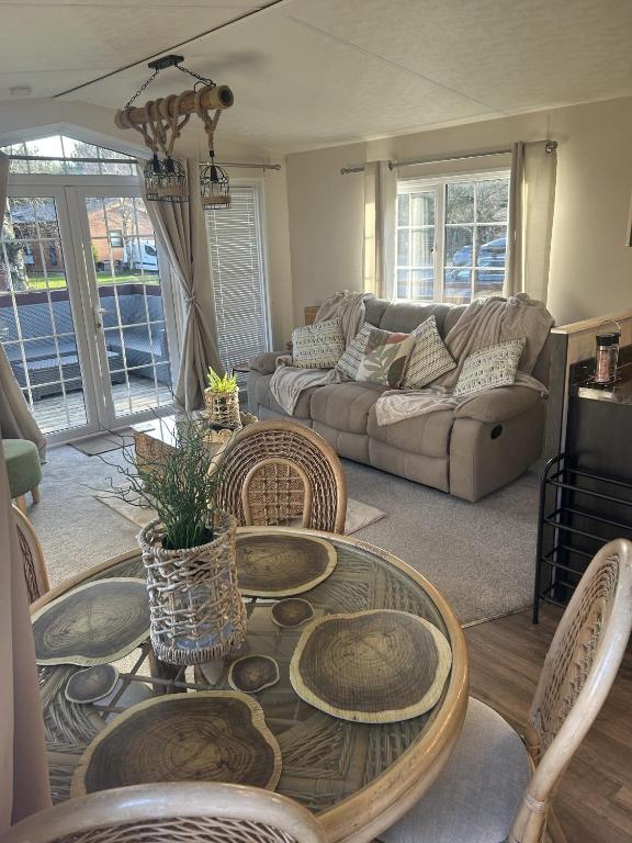 a living room with a table and chairs and a couch at Olive Tree Lodge in West Thirston