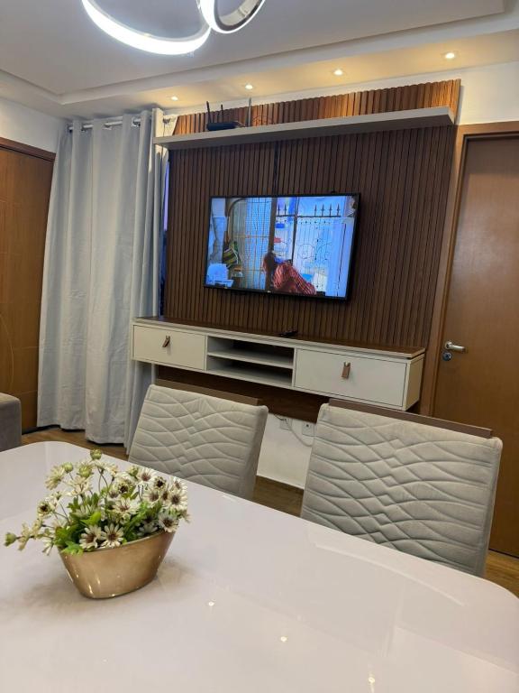 a living room with a table and a tv at Flat ipojuca in Caruaru