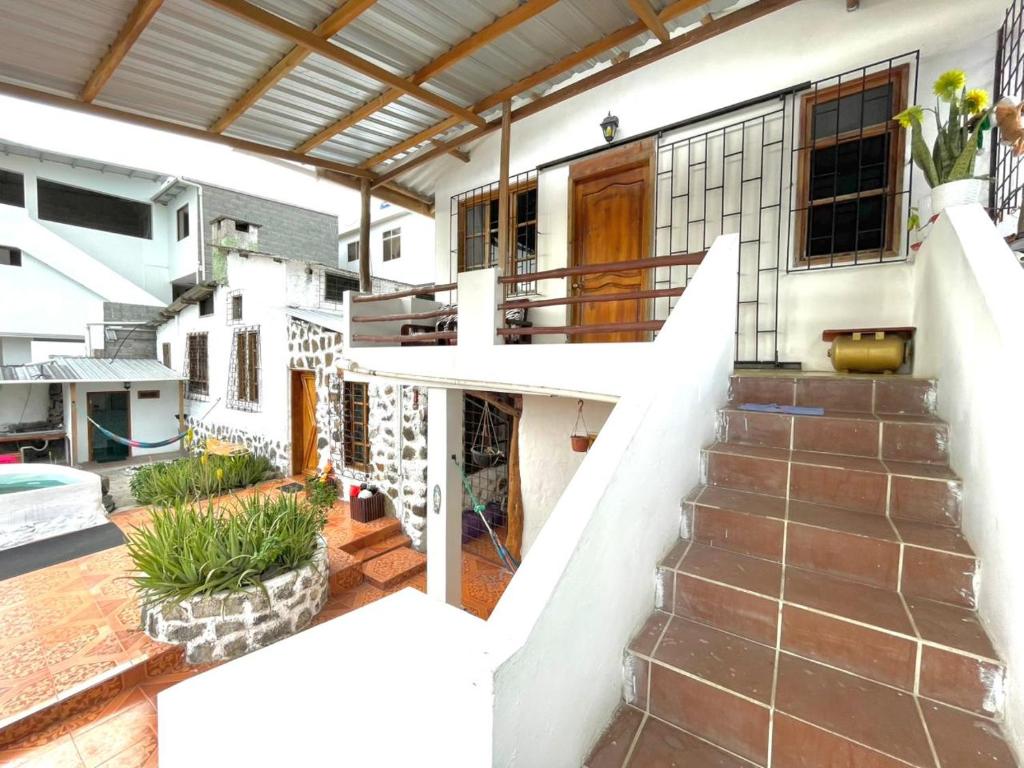 a house with a staircase leading to a balcony at Black&White Brüäder in Puerto Ayora
