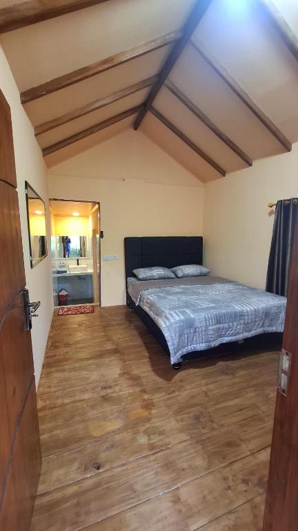 a bedroom with a bed and a wooden floor at SleepHere Homestay in Bayan