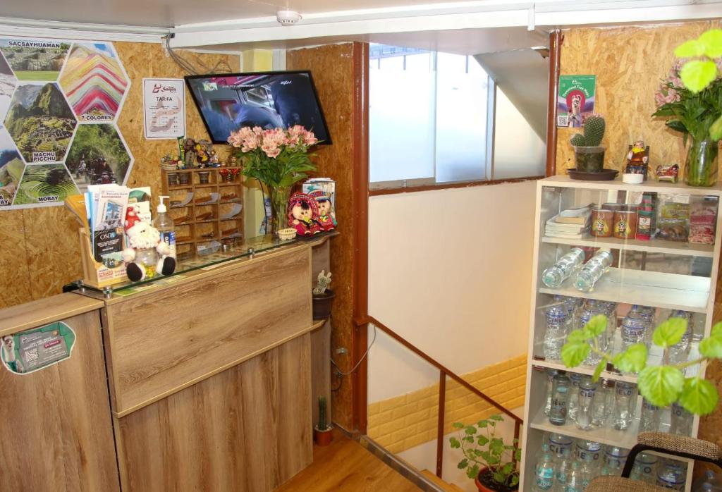 a shop with a tv on the wall and a shelf at PAKARI Wasi in Cusco