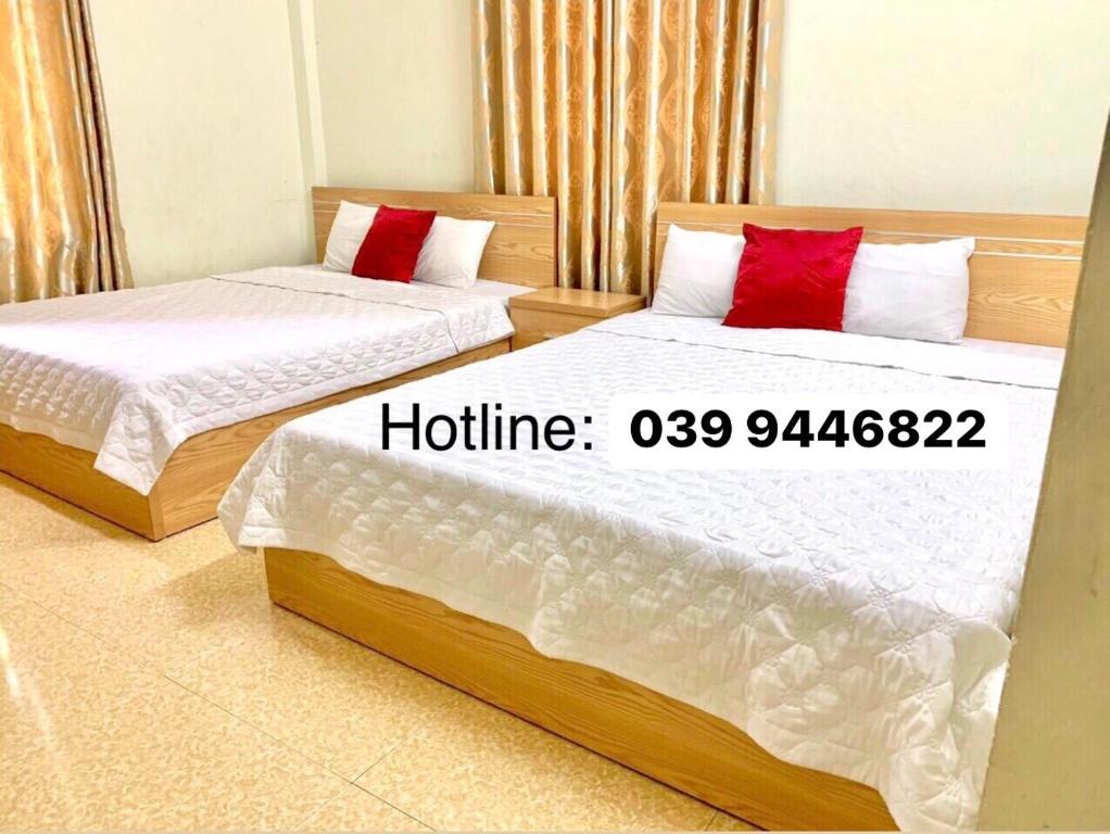 two beds with red pillows in a room at Quynh Yen Hotel in Ha Long