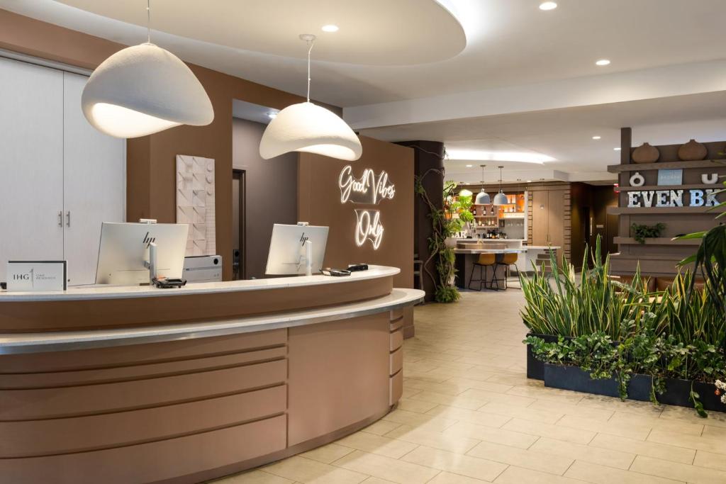 a restaurant lobby with a counter and potted plants at EVEN Hotel Brooklyn by IHG in Brooklyn