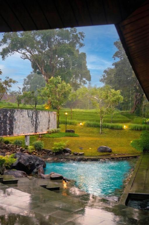 a view of a pond in a garden at Spring River Cisarua in Paragajen