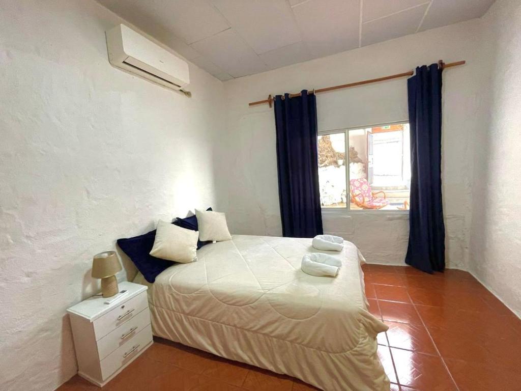 a bedroom with a white bed and a window at BLACK&WHITE -Dis Dihai- in Puerto Ayora