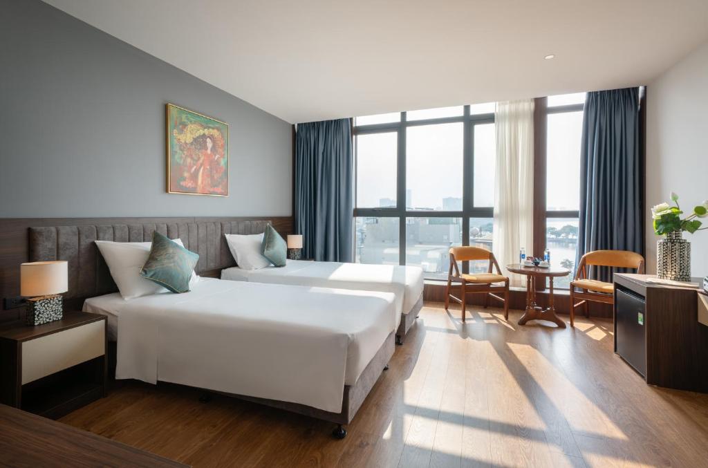 a hotel room with a bed and a large window at Luxe Paradise Hotel Truc Bach in Hanoi