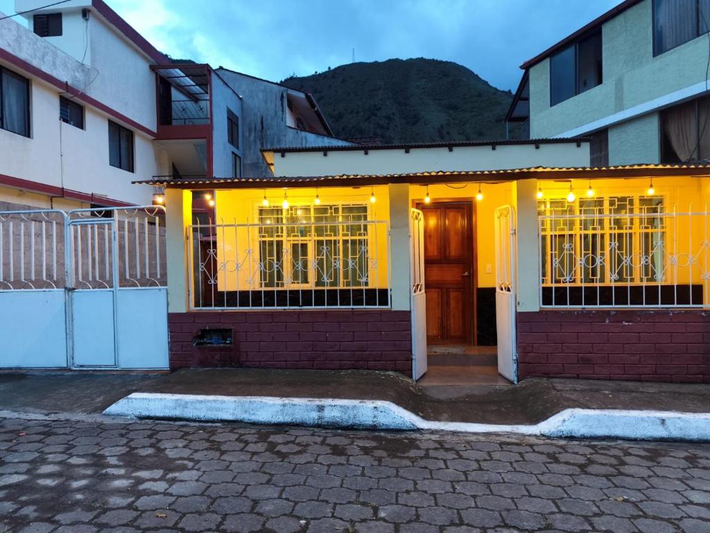 a yellow house with lights on the front of it at Casa Manaba in Baños