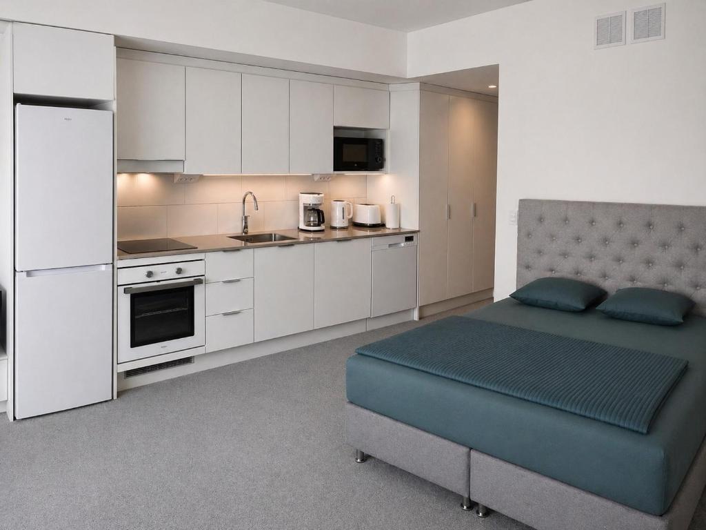 a bedroom with a bed and a kitchen at Nord Heaven in Turku