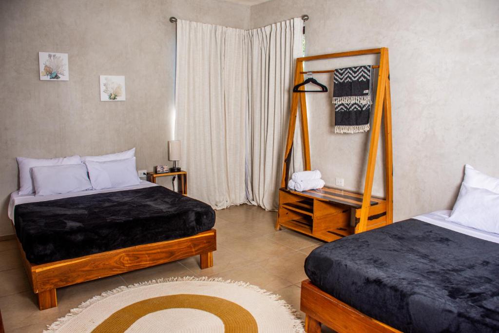 a bedroom with two beds and a mirror at La Familia Casa and Suites in Holbox Island