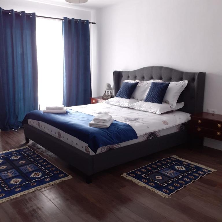 a bedroom with a bed with blue and white pillows at Carpathian Soul Maramures in Bogdan Vodă