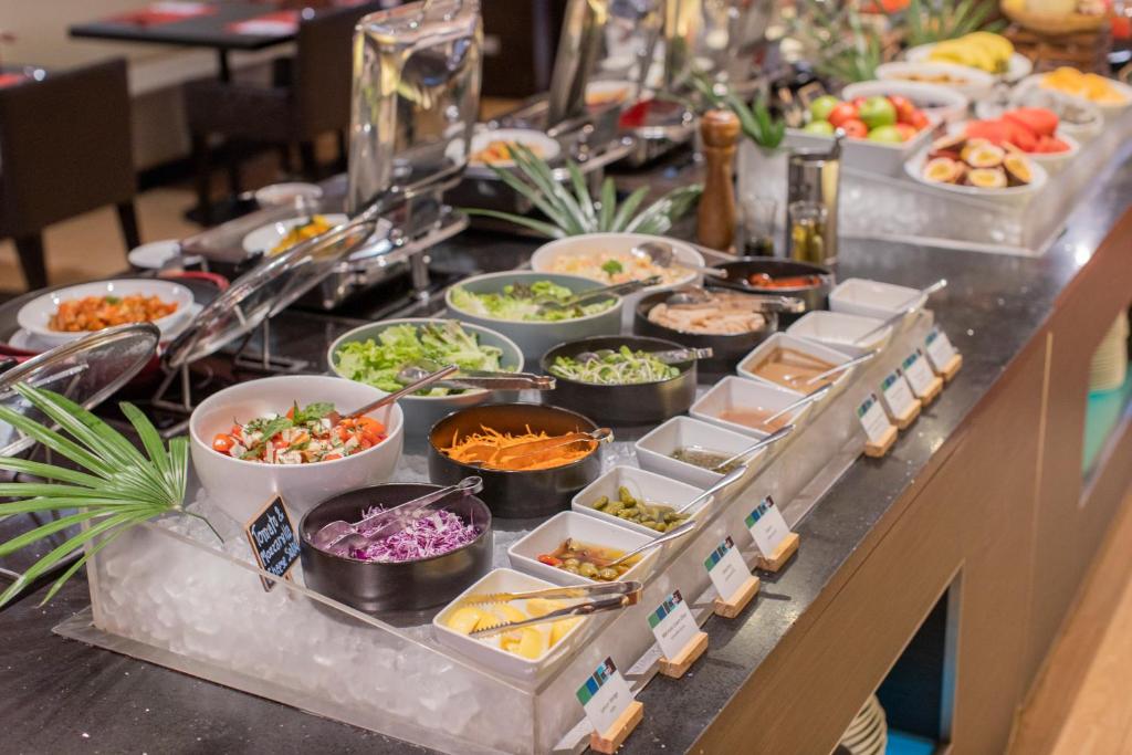 A buffet station displays salads, condiments, fruit and other breakfast toppings.
