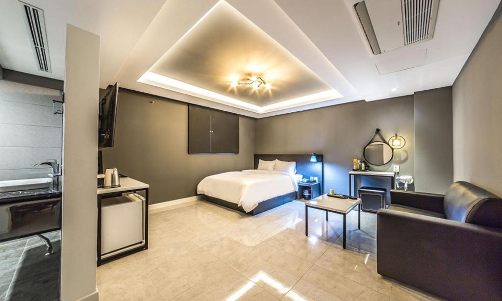 a hotel room with a bed and a couch at Chuncheon Hotel View in Chuncheon