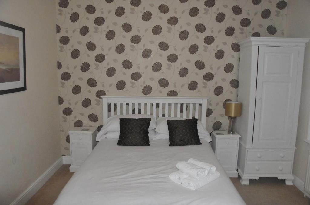 a bedroom with a white bed with two pillows at The Sydney Arms in Dorchester