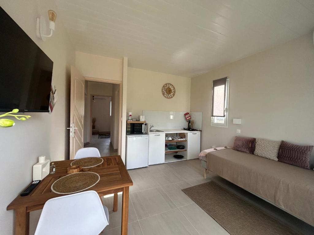a living room with a couch and a table at Appartement Butterfly in Ducos