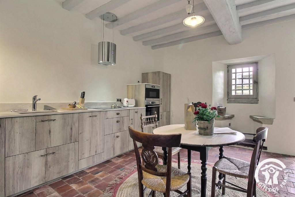 a kitchen with a table and some chairs and a counter at La tour carrée in Trimer