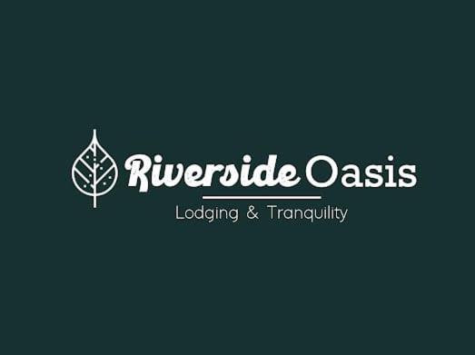 a logo for a landscaping company with a leaf at Riverside Oasis Cabin with A C in Guápiles