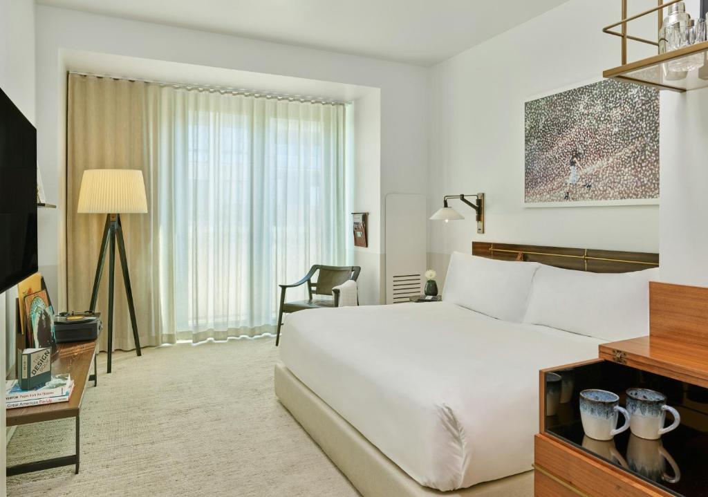a hotel room with a white bed and a desk at Halcyon, a hotel in Cherry Creek, Denver in Denver