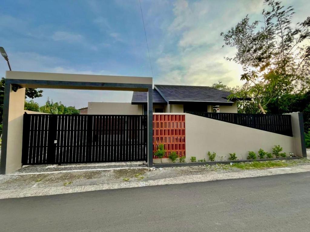 a house with a red door and a white fence at Lepen Home in Ngabean