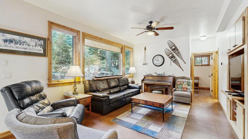a living room with leather furniture and a piano at Rustic-Modern Cabin with Hot Tub Access in McCall