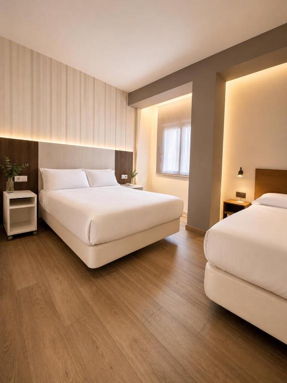 a hotel room with two beds and a window at HOSTAL LETTO DAL MARE in Valencia