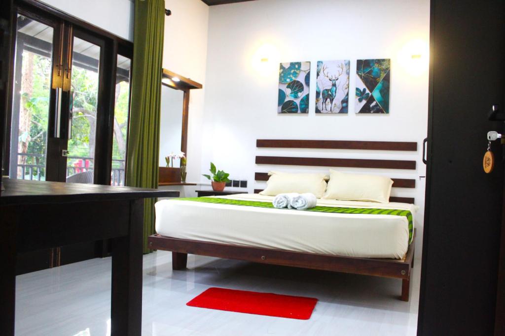 a bedroom with a bed and a desk at The LeoEye Wilpattu in Pahala Maragahawewa