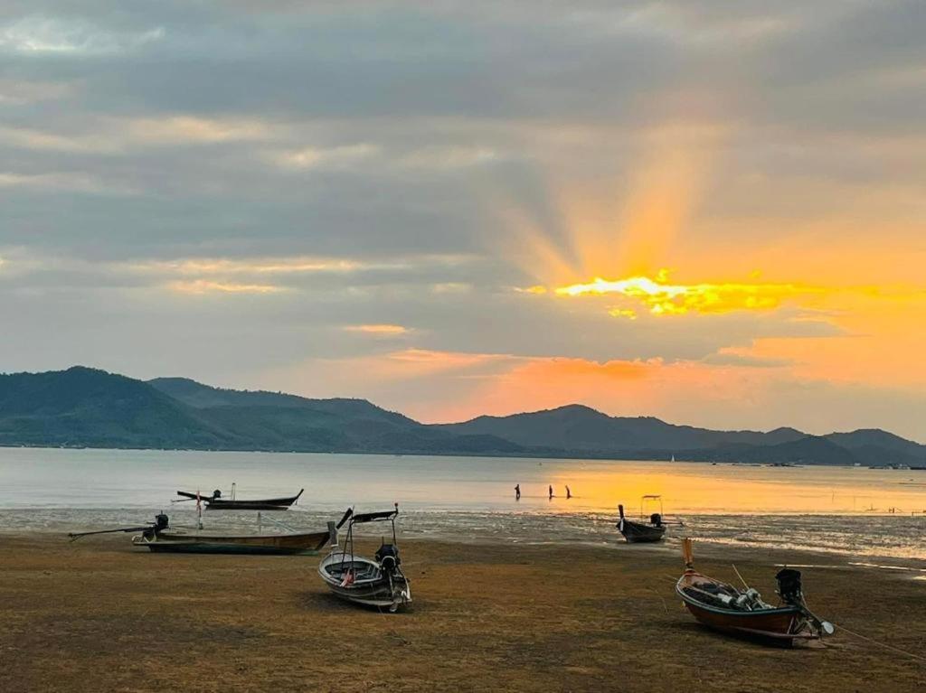 a group of boats on the beach at sunset at Rimlay Bay View 2 in Ko Yao Noi