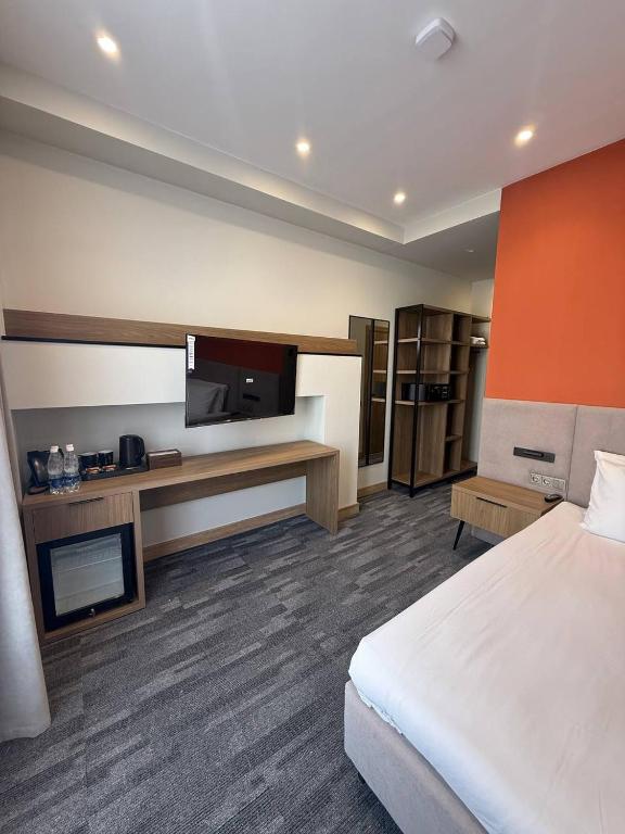 a hotel room with a bed and a flat screen tv at Metropol Hotel Bishkek in Bishkek