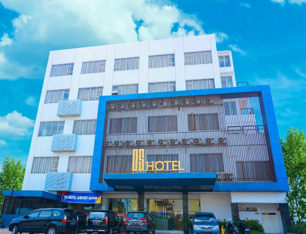 a building with cars parked in front of it at OS Hotel Airport Batam in Batam Center