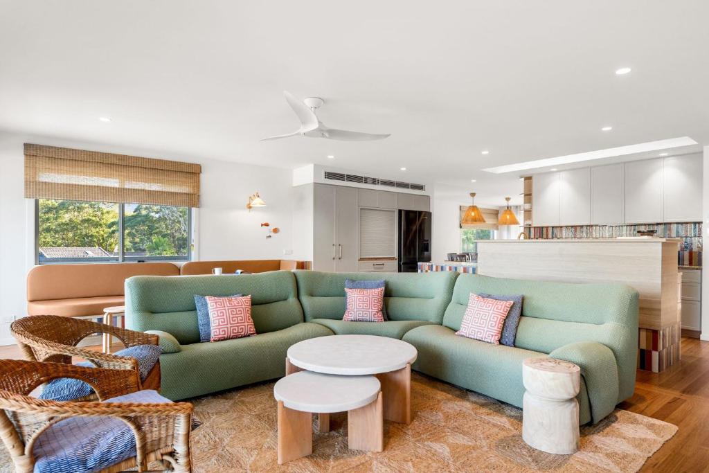 a living room with a green couch and a table at Free night! Pay for 2 stay for 3 in Mollymook