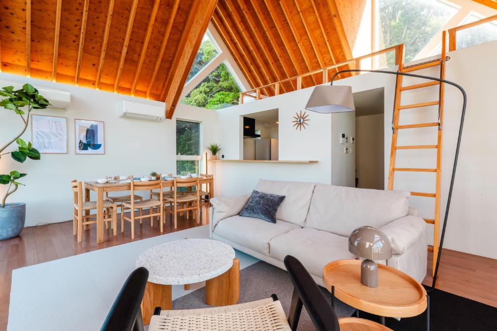 a living room with a couch and a table at 波の音テラス富津ー海眺望グッドデザイン受賞別荘を最大7名1棟貸切 in Futtsu