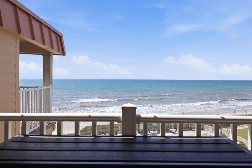a view of the beach from the balcony of a house at Kingfisher Oceanfront Condo w Pool & Elevator in North Topsail Beach