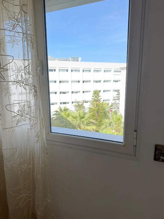 a window with a view of a building at Lac 2 Tunisi in El Aouina Station