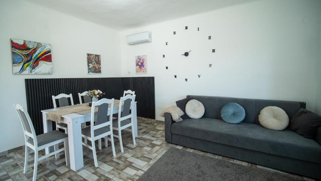 a living room with a couch and a table and chairs at Kun Kuckó Vendégház in Kiskunmajsa