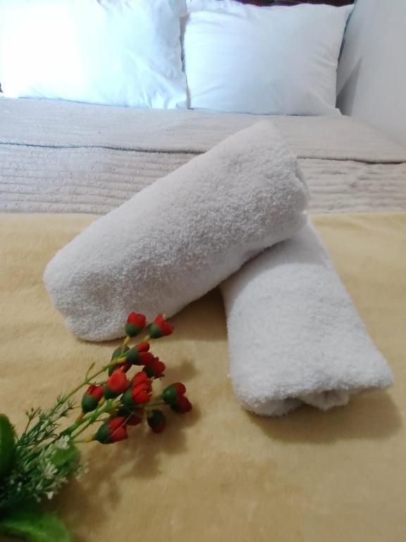 a white blanket on a bed with flowers on it at Lamierda Condotel 2 in Iba