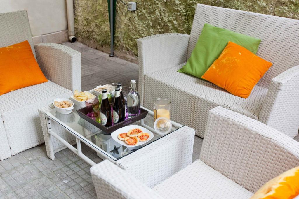 a tray of drinks and food on a patio with wicker chairs at Colosseo Accomodation in Rome