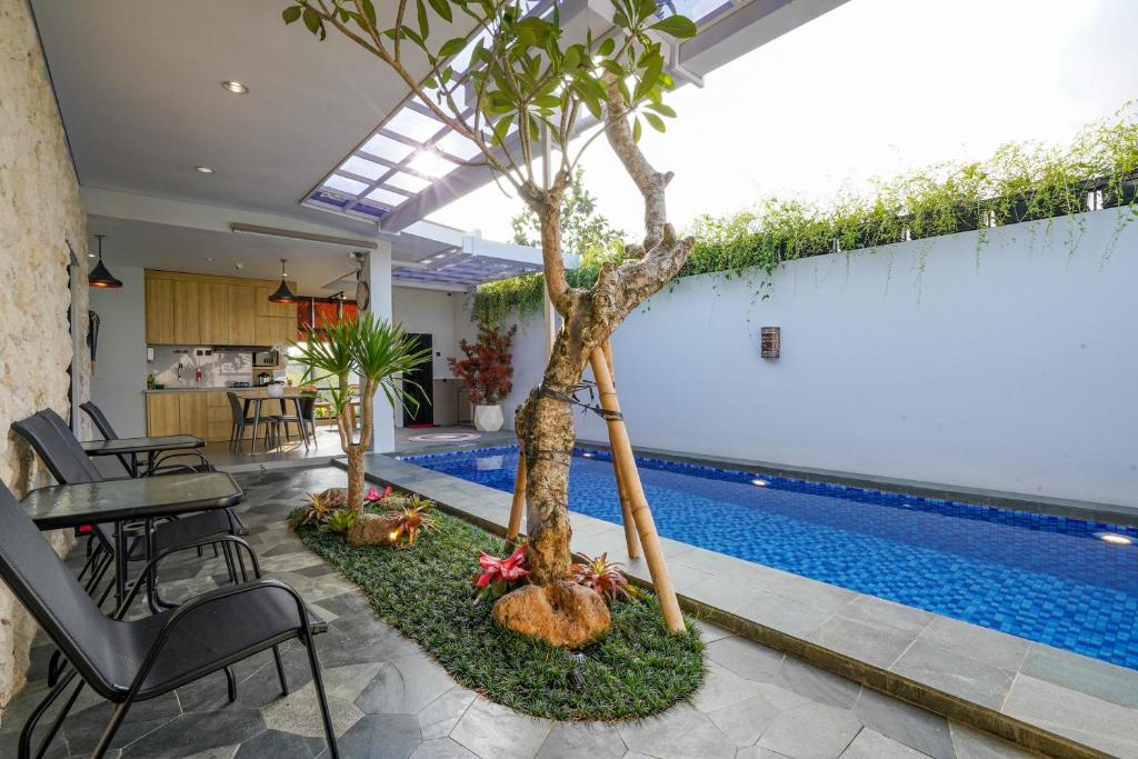 a house with a swimming pool with trees in the yard at The Lavana Infinity Jogja Villa in Salakan