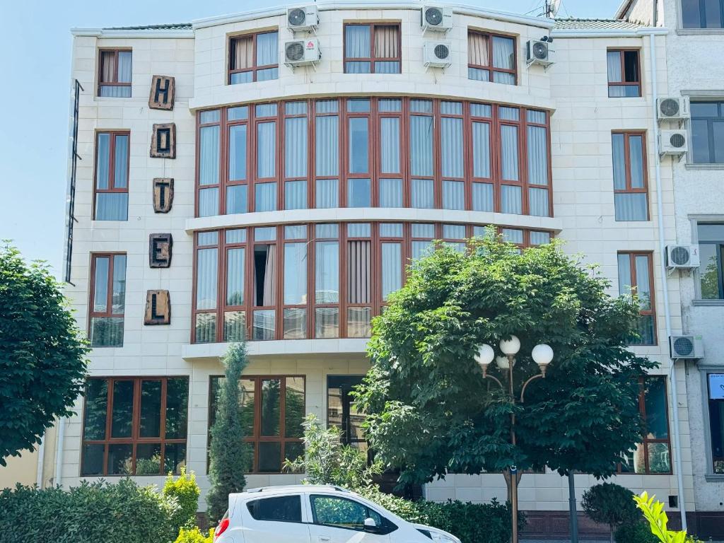 a white car parked in front of a building at KHAN Hotel in Kokand