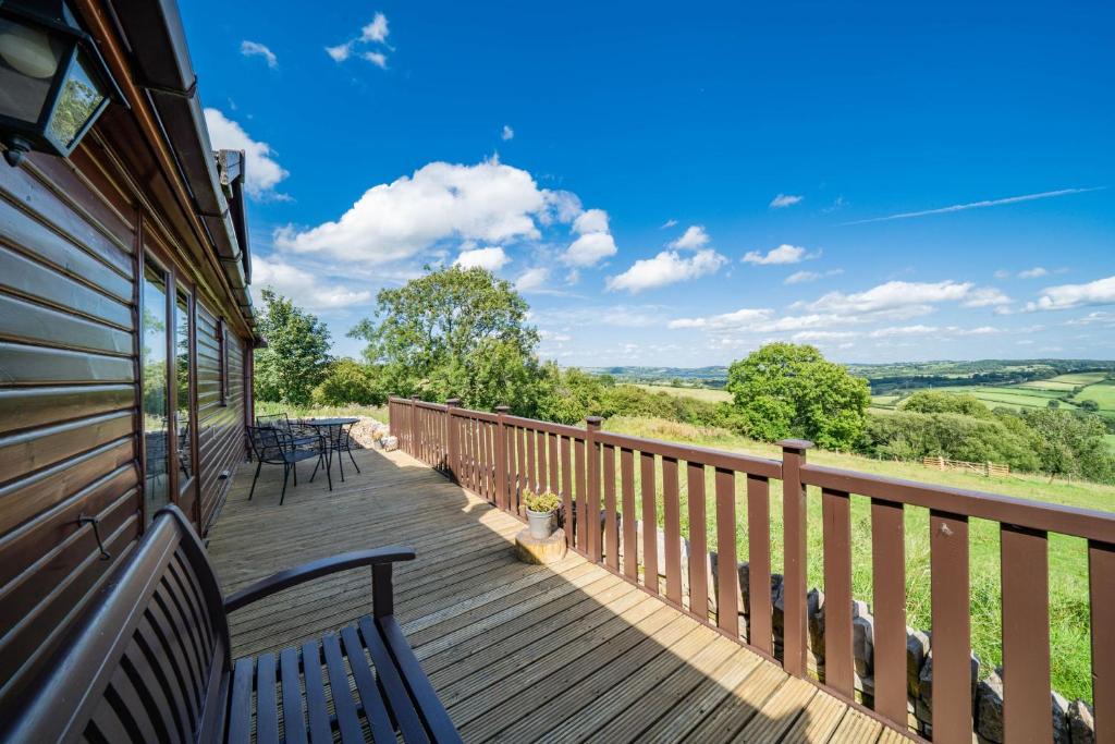 a wooden deck with benches and tables on it at Ewe Lodge in Ashbourne