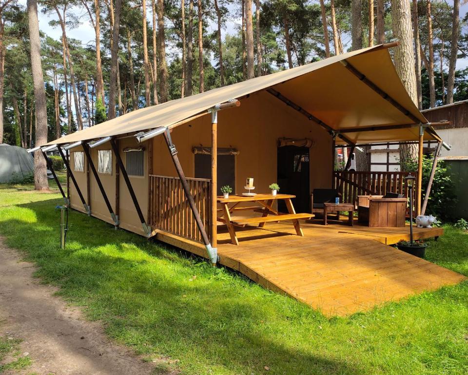 ein großes Zelt mit Holzterrasse im Gras in der Unterkunft Campingplatz Wusterhausen in Wusterhausen