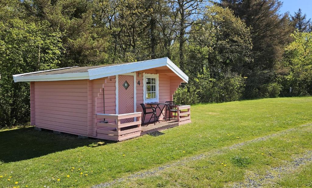 a pink shed in a field of grass at Bygholm Camping og aktiviteter in Vesløs