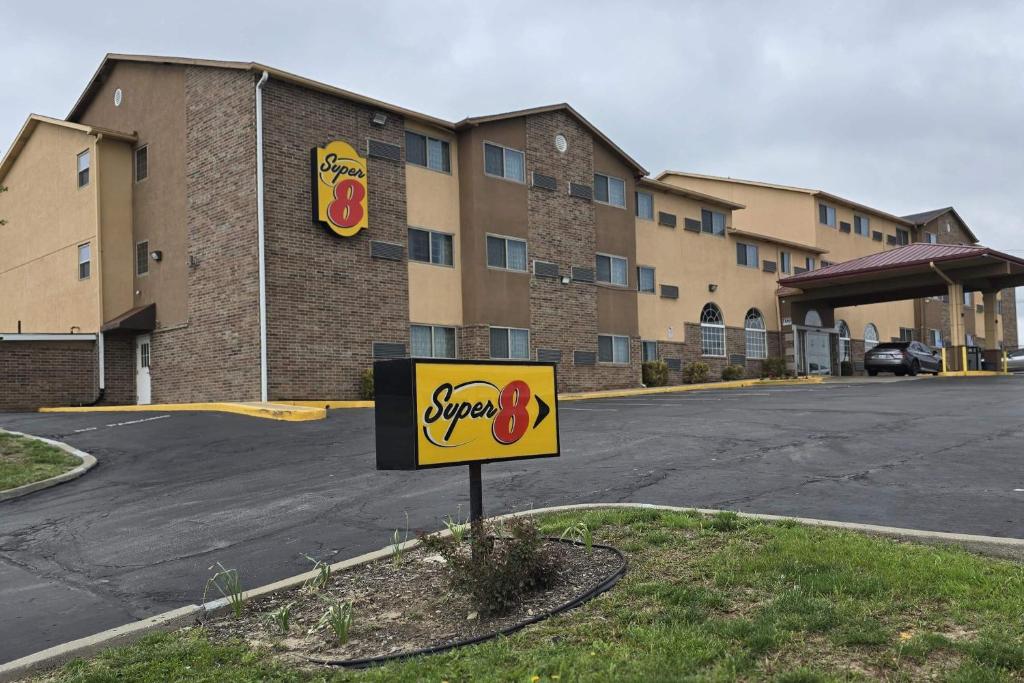 a sign in a parking lot in front of a hotel at Super 8 by Wyndham Kansas City in Kansas City