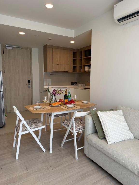 a living room with a table and a couch at Avrora Laguna Residences Sky Park in Ban Thalat Choeng Thale