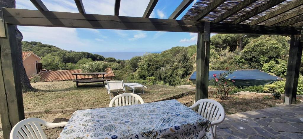 a table and chairs on a patio with a view of the ocean at Villa Cedro in Capoliveri